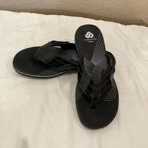 Clark’s Cloud Steppers in black patent thong sandals. Slight wear. Size 8.